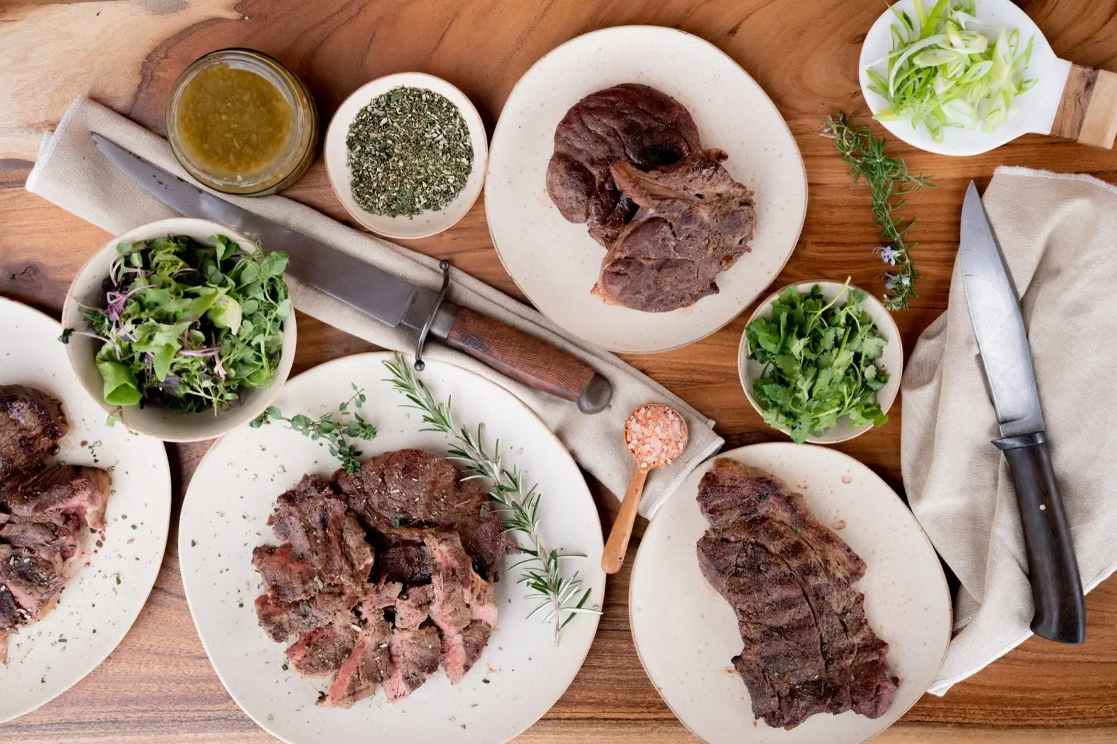 Cooked Mangaroa steaks plated with greens and dressings