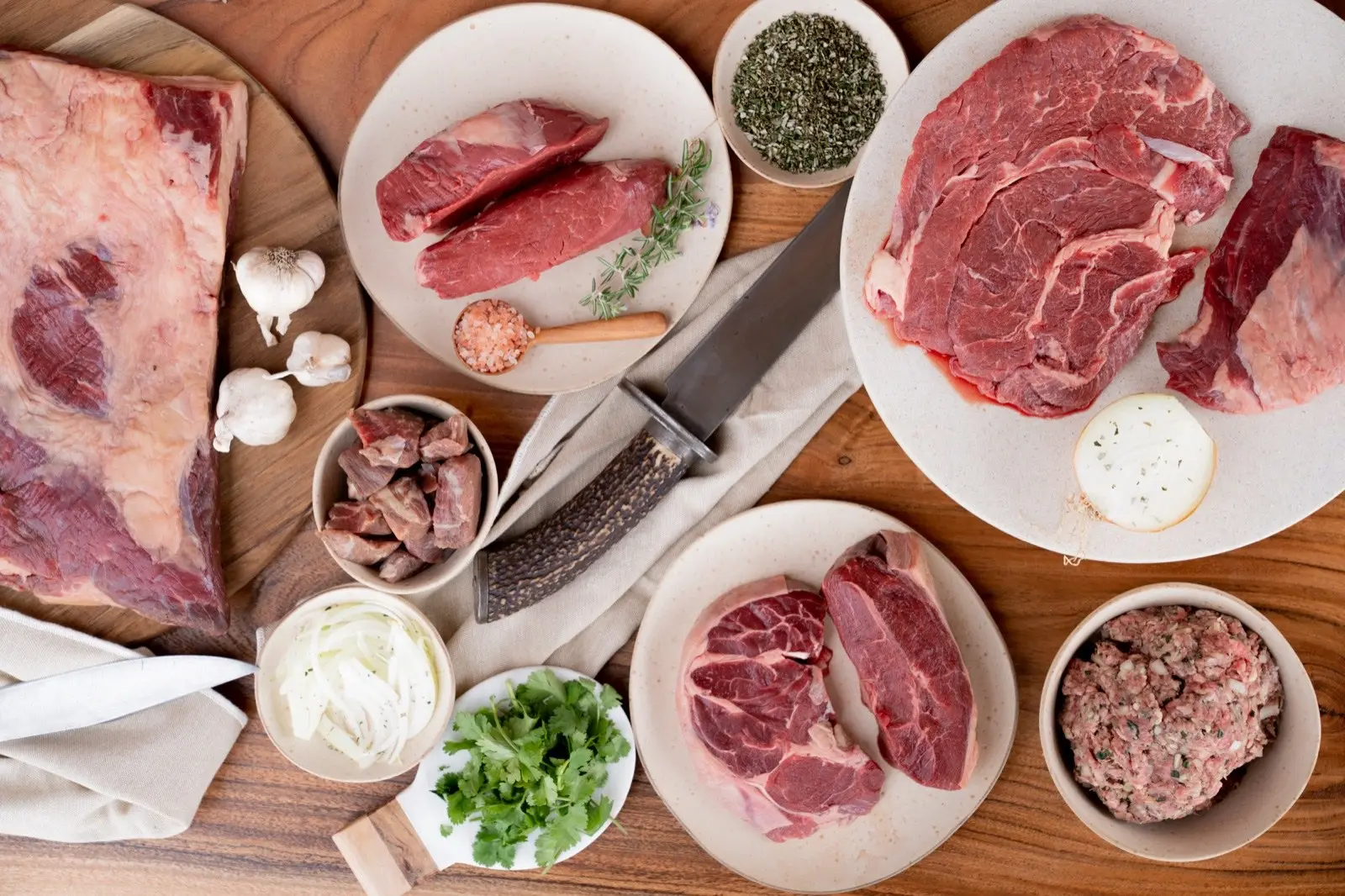 Raw Mangaroa beef cuts laid out on a wooden board